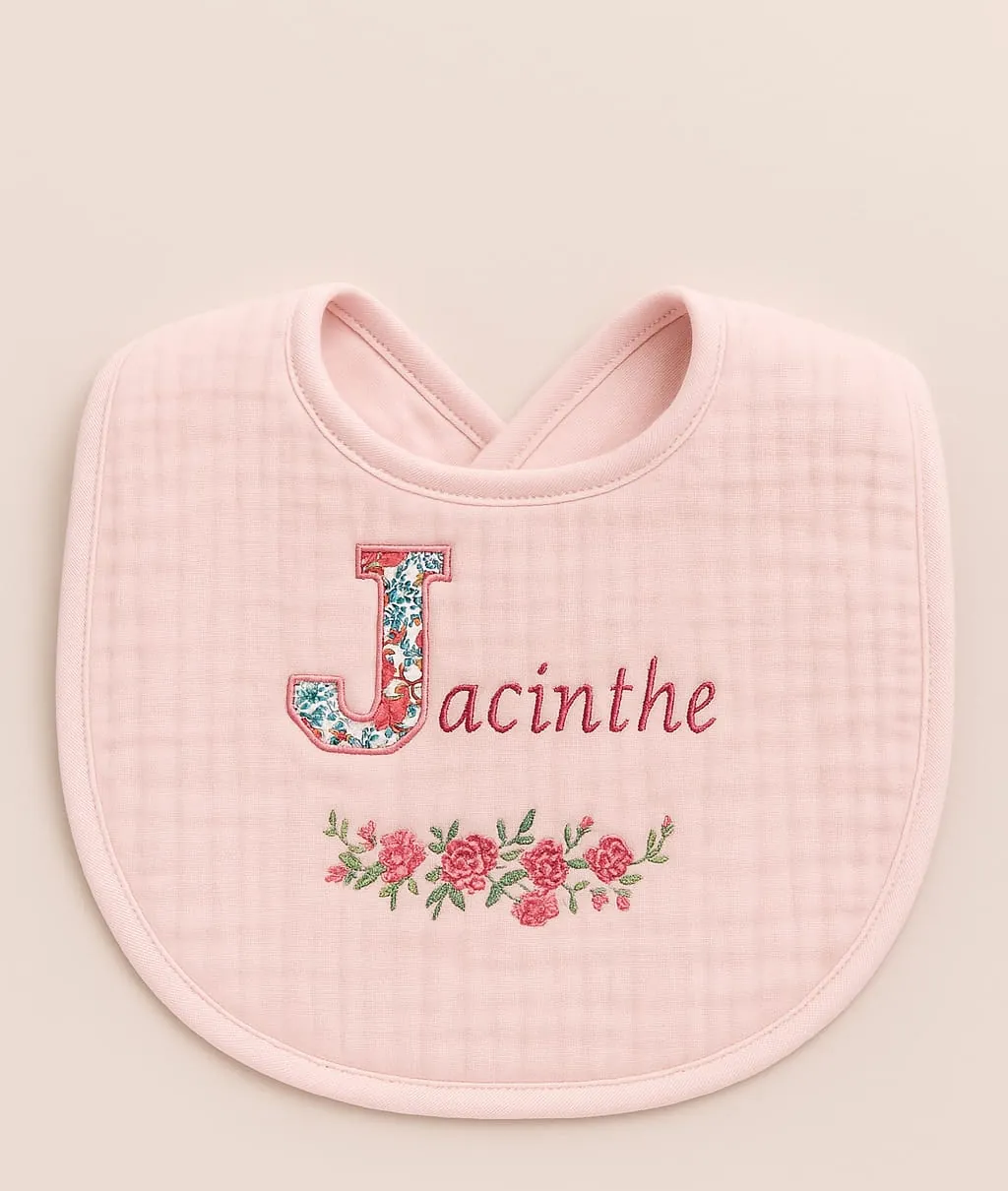 Bavoir rond rose poudré brodé du prénom Jacinthe avec une initiale en tissu fleuri