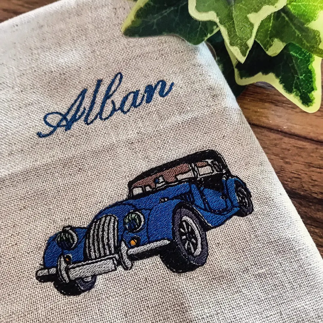 Serviette de table en lin brodée du prénom Alban avec une voiture ancienne bleue